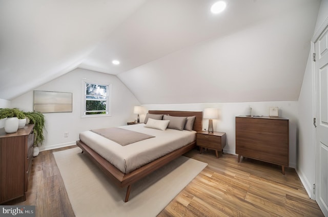 bedroom with lofted ceiling and wood-type flooring