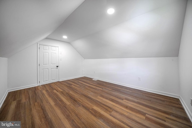 additional living space with dark hardwood / wood-style flooring and lofted ceiling