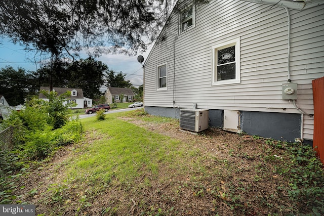 exterior space with central air condition unit and a yard