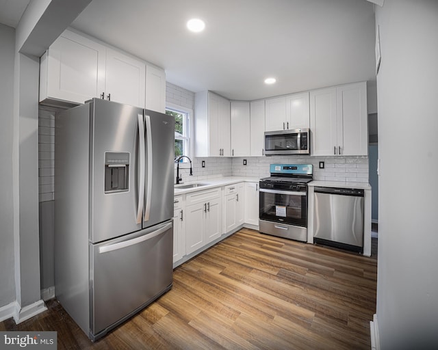 kitchen featuring sink, appliances with stainless steel finishes, white cabinetry, and light wood-type flooring