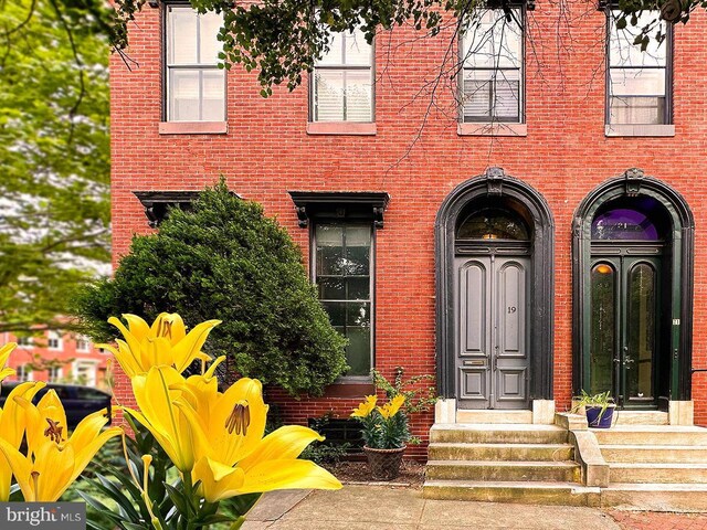 entrance to property featuring french doors and brick siding