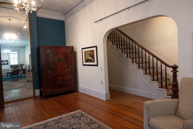 19 S Stricker St, Baltimore, MD 21223 - stairs featuring crown molding, a notable chandelier, arched walkways, hardwood / wood-style floors, and baseboards