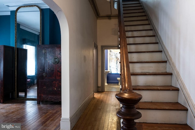 19 S Stricker St, Baltimore, MD 21223 - staircase featuring arched walkways, ornamental molding, and wood-type flooring