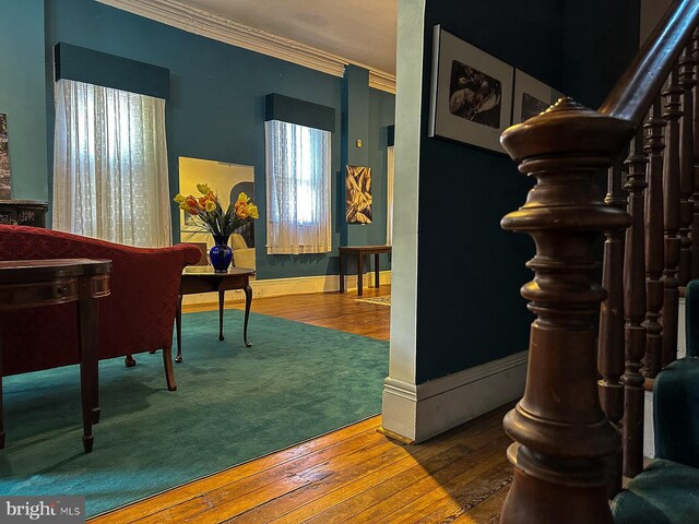 living room with ornamental molding, stairway, hardwood / wood-style floors, and baseboards