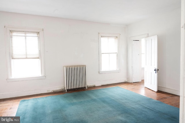 19 S Stricker St, Baltimore, MD 21223 - empty room featuring wood finished floors and radiator heating unit