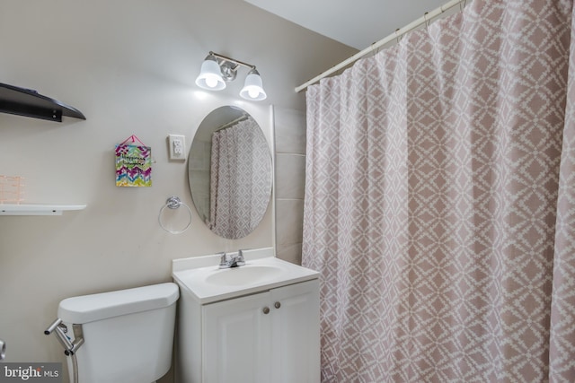 bathroom with toilet, vanity, and curtained shower