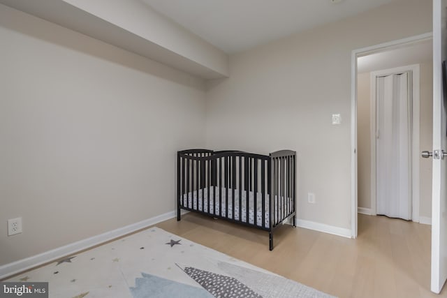 bedroom featuring a crib and hardwood / wood-style floors