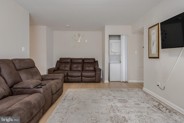 living room with stacked washer and dryer and light hardwood / wood-style flooring