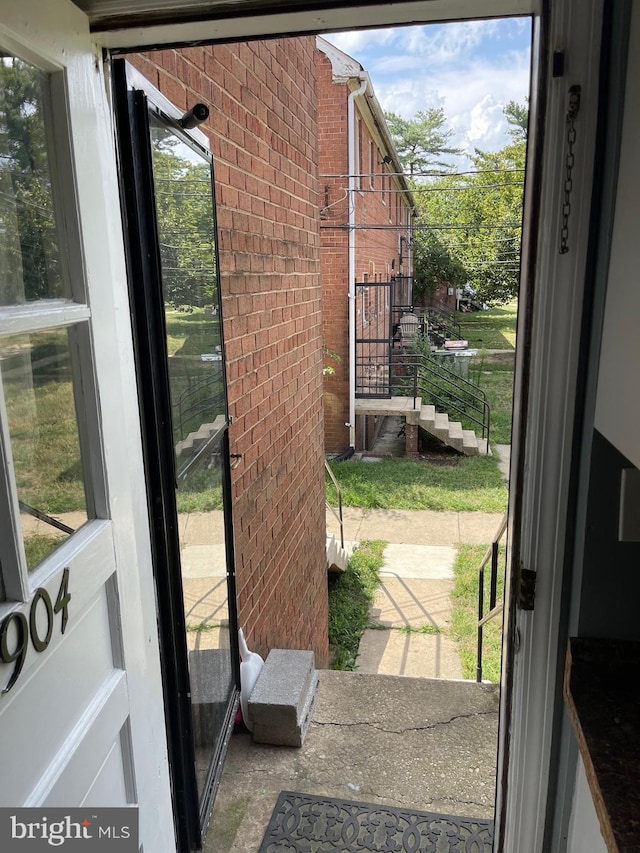 doorway featuring brick wall