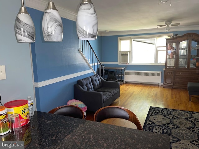 living room with ceiling fan, light wood-type flooring, crown molding, and radiator heating unit