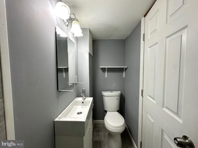 bathroom with hardwood / wood-style floors, vanity, and toilet