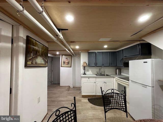 kitchen featuring white appliances, sink, light hardwood / wood-style flooring, and gray cabinets