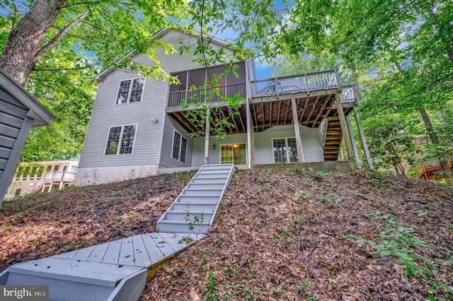 view of front of home with a sunroom, a deck, and stairs