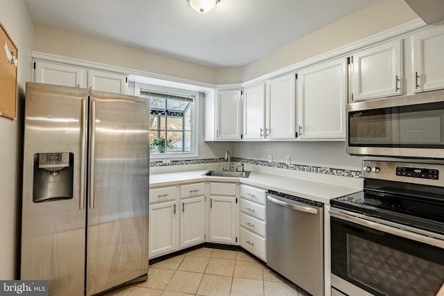 kitchen with sink, white cabinetry, stainless steel appliances, and light tile patterned floors