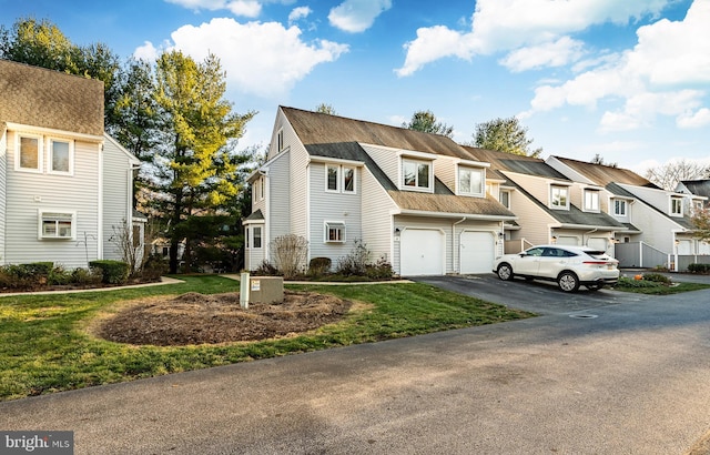 view of property with a garage and a front lawn