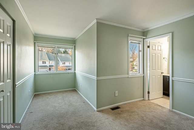 unfurnished room with crown molding and light carpet