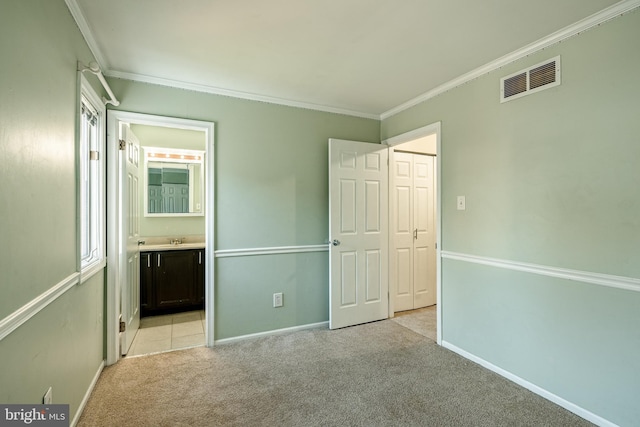 unfurnished bedroom with light carpet, ensuite bath, ornamental molding, and sink