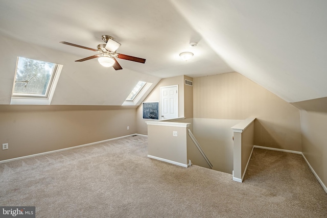 bonus room featuring vaulted ceiling with skylight, light carpet, and a wealth of natural light