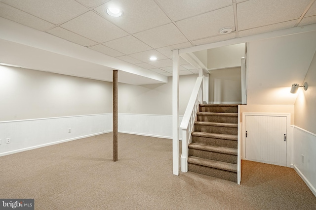 basement featuring carpet flooring and a drop ceiling