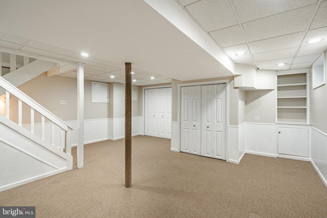 basement featuring carpet flooring and a paneled ceiling