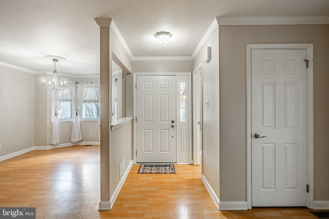 foyer entrance featuring a chandelier, light hardwood / wood-style flooring, and ornamental molding