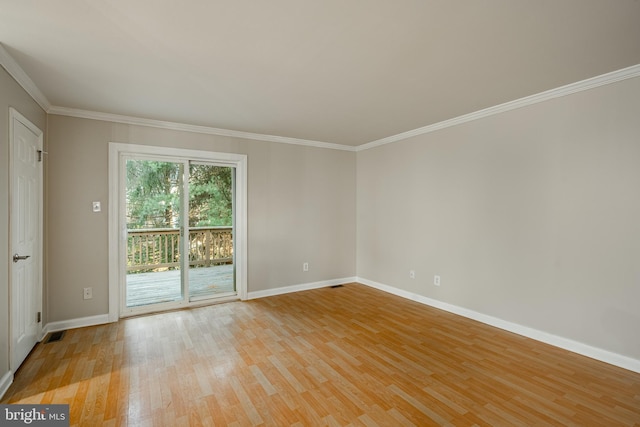 spare room with ornamental molding and light wood-type flooring