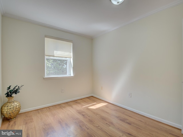empty room with baseboards, light wood-style flooring, and crown molding