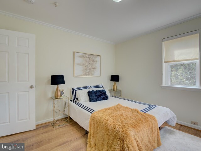 bedroom with hardwood / wood-style floors and ornamental molding