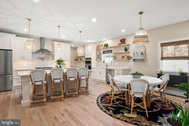 dining space featuring plenty of natural light, sink, and light wood-type flooring