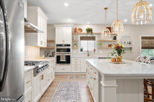 kitchen featuring backsplash, appliances with stainless steel finishes, open shelves, and a sink