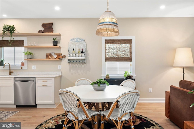 dining area featuring sink and light wood-type flooring