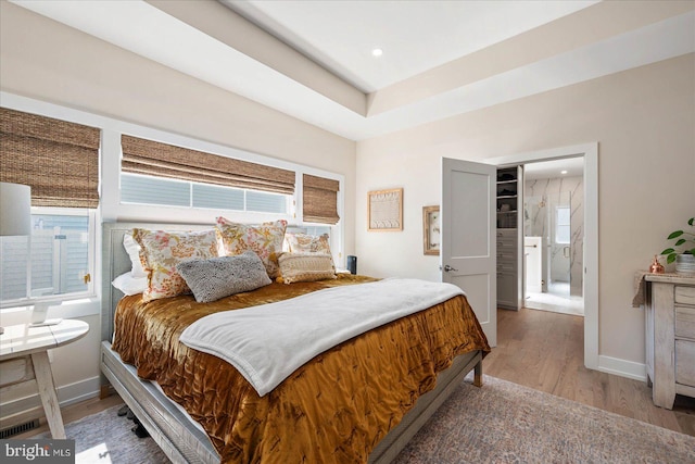 bedroom featuring multiple windows and hardwood / wood-style flooring