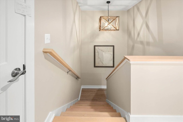 stairs with wood finished floors and baseboards