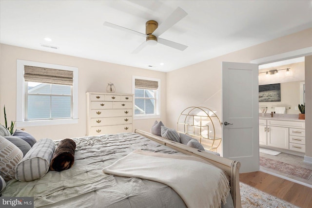 bedroom featuring light wood-type flooring, connected bathroom, and ceiling fan