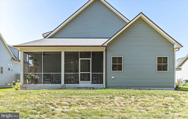 back of house with a sunroom and a lawn