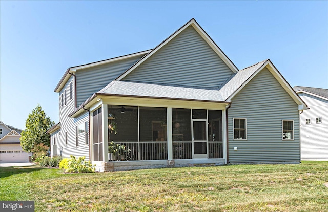 back of house featuring a lawn, a garage, and a sunroom