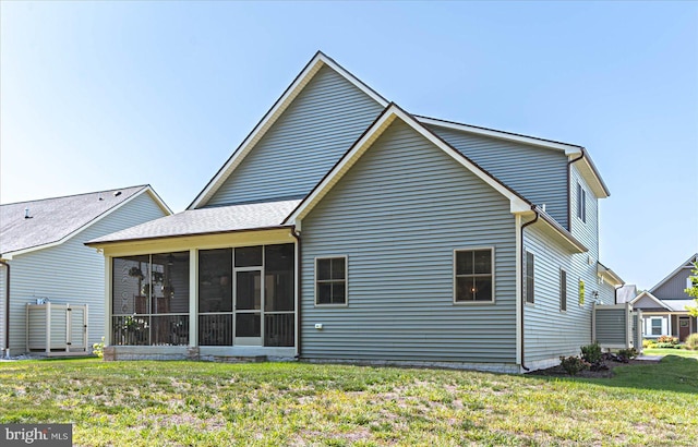 back of property featuring a yard and a sunroom