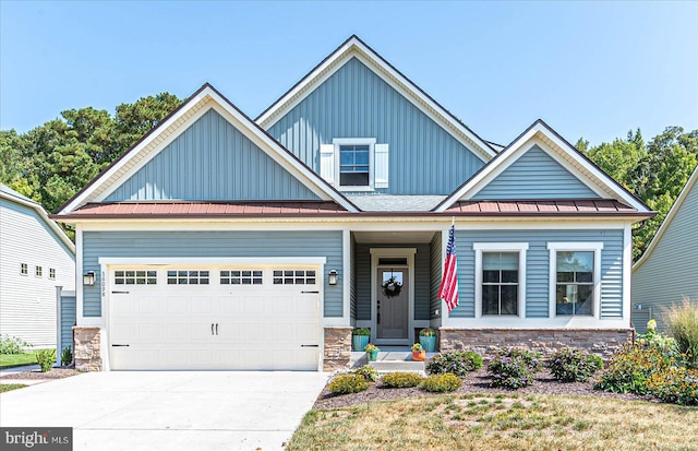 craftsman-style house featuring board and batten siding, stone siding, driveway, and a standing seam roof