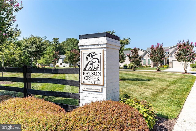 community / neighborhood sign featuring a yard, a residential view, and fence