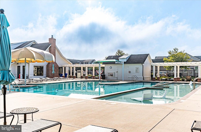 view of swimming pool with a patio and a pergola