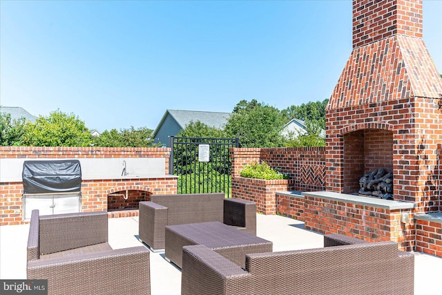 view of patio with an outdoor living space with a fireplace and area for grilling