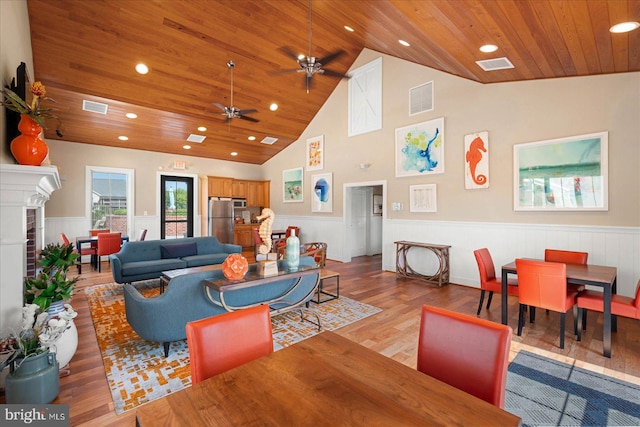 living room with ceiling fan, light wood-type flooring, high vaulted ceiling, and wooden ceiling