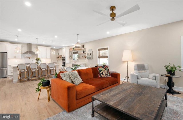 living room featuring light hardwood / wood-style flooring and ceiling fan