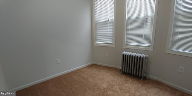 spare room with radiator, light carpet, and a healthy amount of sunlight