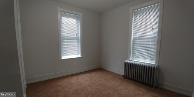 carpeted spare room with radiator heating unit