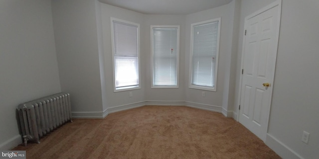 carpeted spare room with radiator heating unit