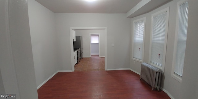 hallway featuring radiator and dark hardwood / wood-style flooring