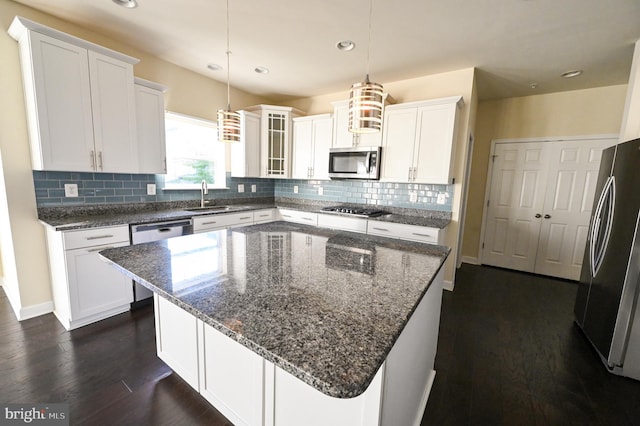 kitchen with white cabinetry, glass insert cabinets, stainless steel appliances, and a center island