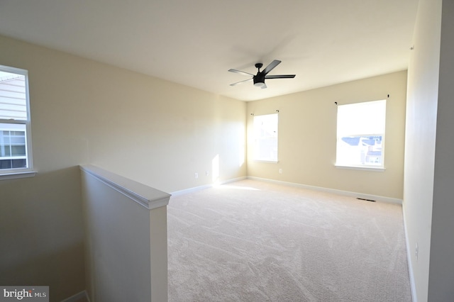 carpeted spare room featuring ceiling fan