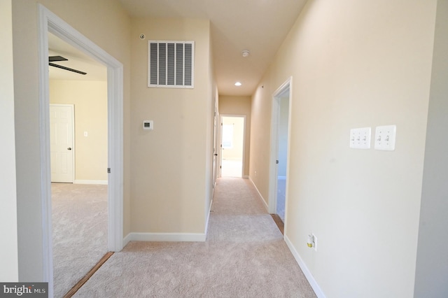 hallway featuring light colored carpet